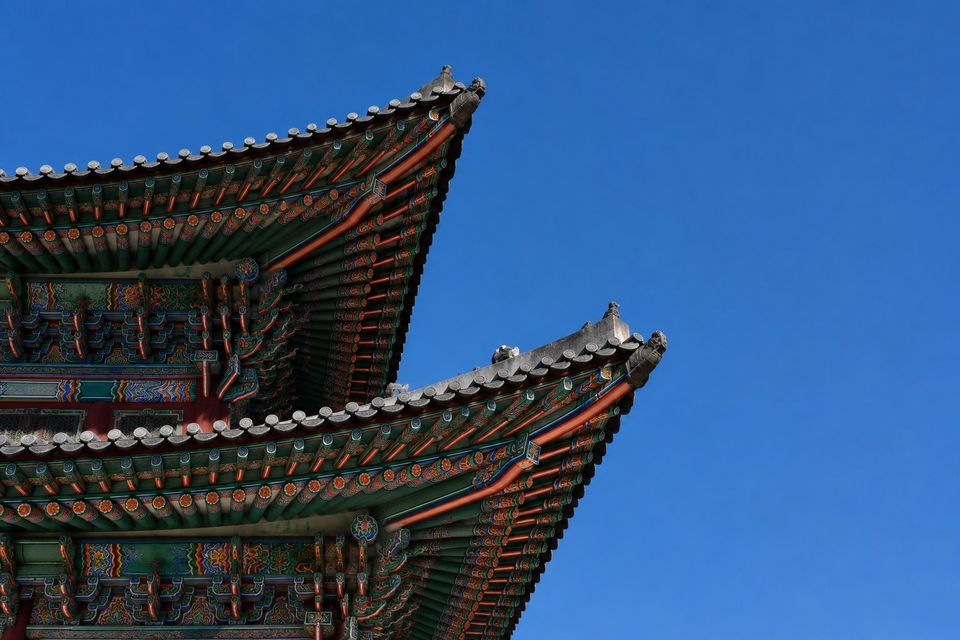 Painted palace eaves against a deep blue sky